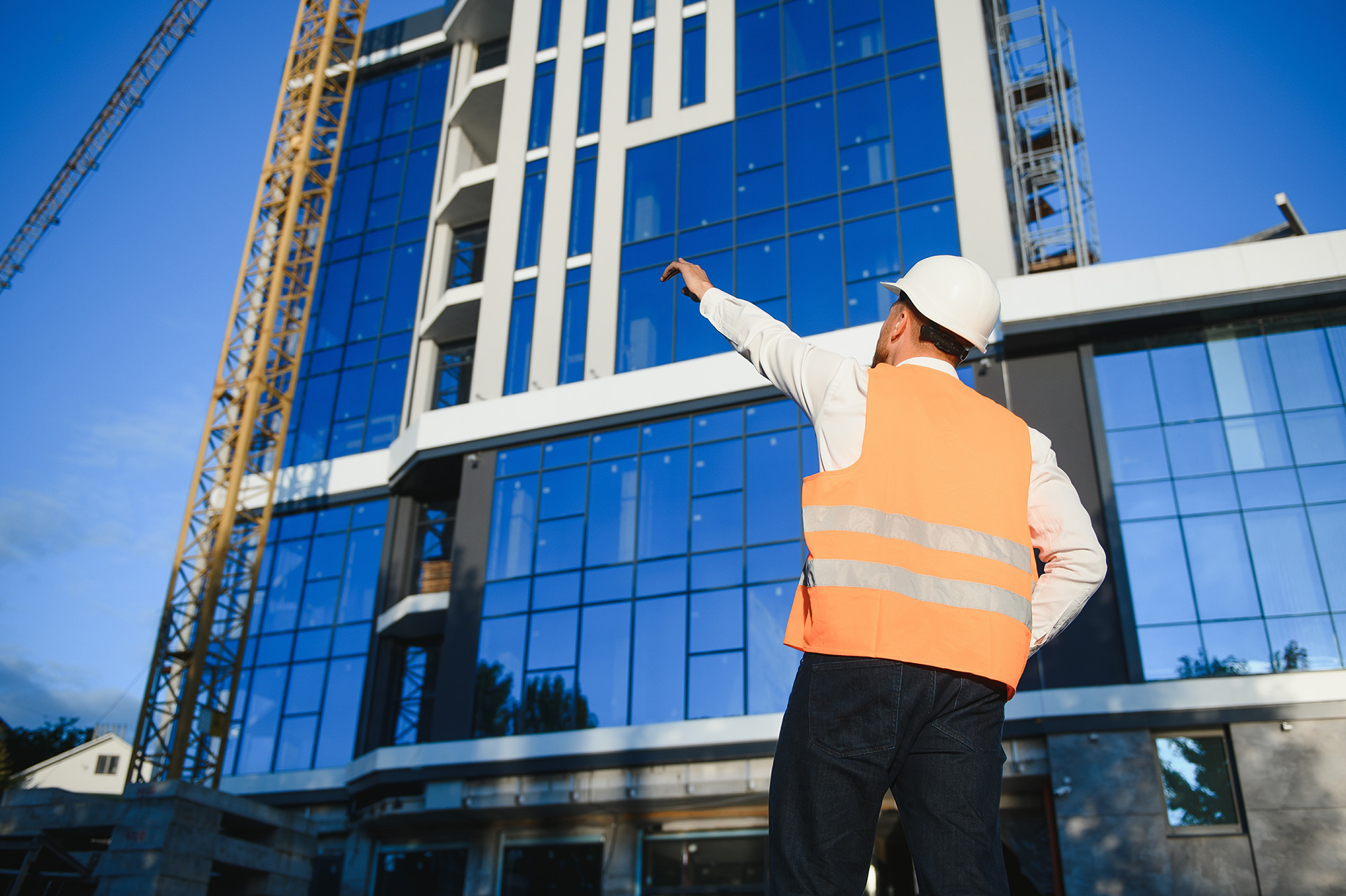Man Pointing At High Rise Modern Office Building Performing A Condition Survey